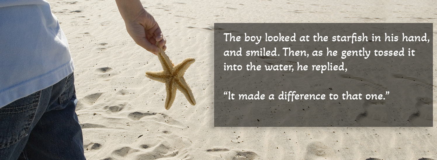 Boy holding starfish walking on beach